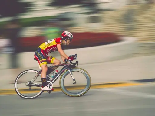 Kolarz w żółto-czerwonym stroju pędzi na rowerze. Ile czasu zajmie mu pokonanie 50 km na rowerze?