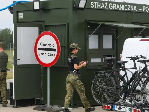 Strażnicy graniczni prowadzą kontrole na granicy niemieckiej. Obok zielonego punktu kontrolnego stoją dwa rowery na bagażniku samochodu.