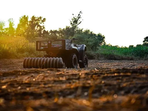 ATV with a roller attachment, ready for field work. This is one of many tractor attachments that can help prepare the soil.
