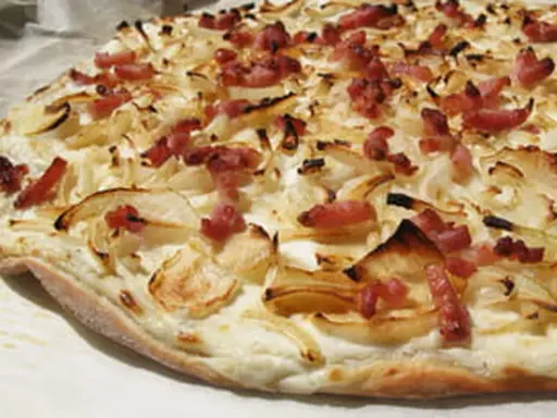 Flammekueche croustillante, garnie d'oignons et de lardons. Une recette facile pour un plat savoureux.
