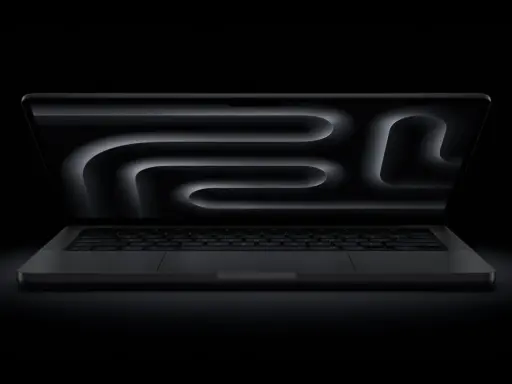 MacBook Pro z polskim układem klawiatury, ciemny ekran z abstrakcyjnym wzorem.