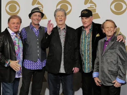 Fem leende medlemmar av The Beach Boys poserar för ett foto.