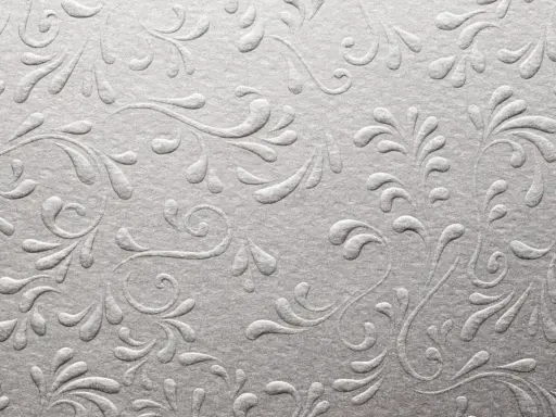 Srebrzyste, wytłaczane wzory roślinne na papierze, przypominające eleganckie uszlachetnienia druku.