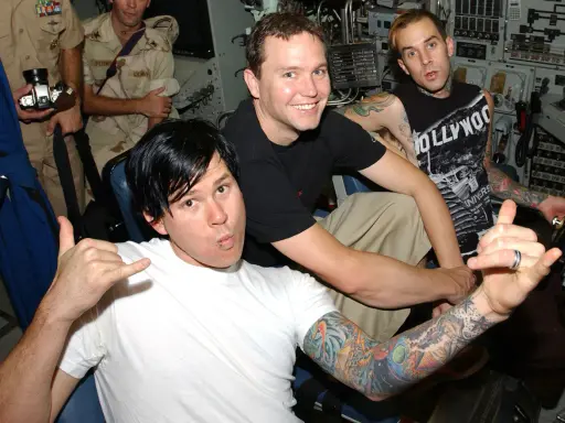 Mark Hoppus, Tom DeLonge och Travis Barker från Blink-182 i Sverige. De poserar med tatueringar och glada miner.
