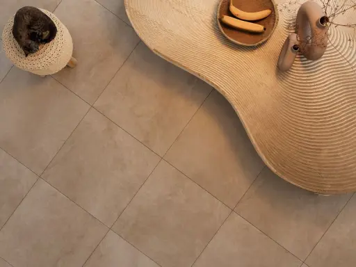 Kot śpi na pufie, obok falistego stolika z bananami i wazonami. Podłoga z gres lappato czyszczenie jest nieskazitelna.