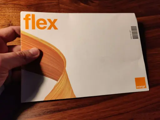 Dłoń trzyma kopertę z napisem "flex" i logo Orange. To oferta Orange Flex.