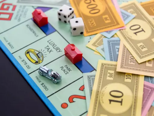 Na planszy Monopoly leżą pionki, kostki i banknoty. Czas na wielką rozgrywkę, ale gramy!