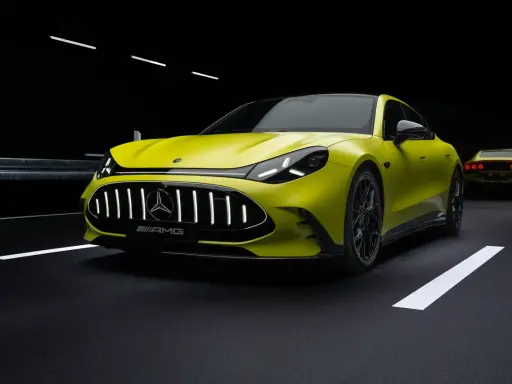 Ein leuchtend gelber AMG Elektro-Sportwagen mit beleuchtetem Kühlergrill steht auf dunklem Asphalt.