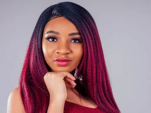 Una giovane donna con capelli color prugna, un look audace che le sta benissimo.