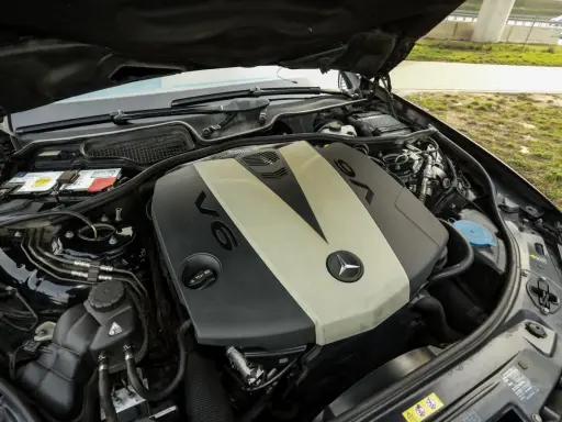 Silnik V6 om642 Mercedesa z otwartą maską. Widoczny akumulator, płyny i elementy osprzętu.