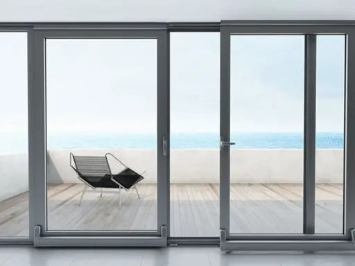 Ventanas osciloparalelas con vista al mar. Un sillón moderno en la terraza de madera.