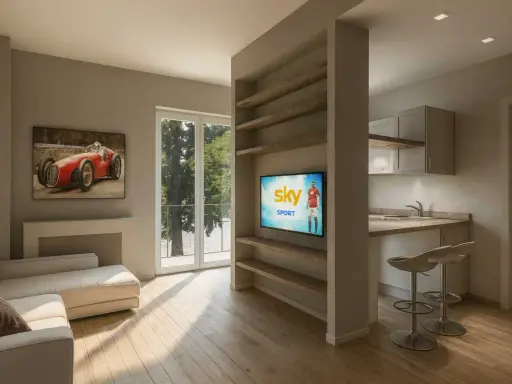 Soggiorno moderno con divano, quadro d'auto d'epoca e cucina a vista. Perfetto per chi cerca case ristrutturate con stile.