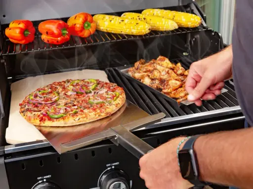 Pyszna pizza z grilla węglowego, obok kurczak i kukurydza.
