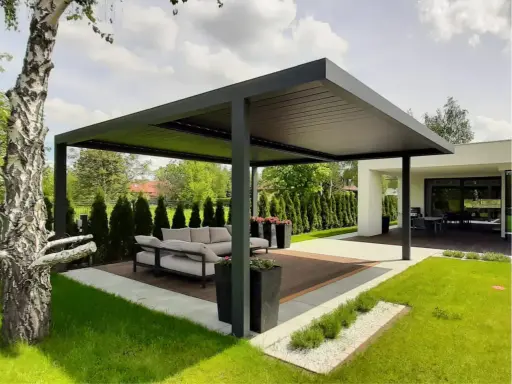 Nowoczesna pergola z wygodną sofą i stolikiem to idealne miejsce do wypoczynku. Zastanawiasz się, co położyć na taras? Tutaj widzisz gotową aranżację.