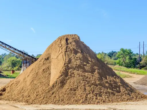 Ogromna hałda piasku, kluczowego składnika do produkcji betonu. Zastanawiasz się, ile piasku na m3 betonu? Tu jest go mnóstwo!