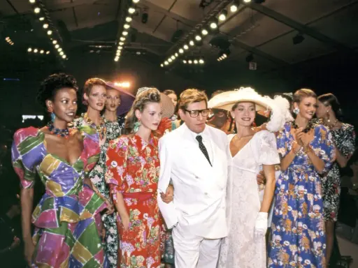 Models and designer Yves Saint Laurent at the Staley Wise Gallery fashion show, showcasing vibrant, patterned dresses and bold accessories.