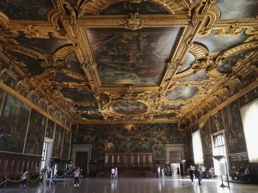 La salle du grand conseil du palais des doges, un chef-d'œuvre orné de peintures et de dorures, accueille des visiteurs émerveillés.