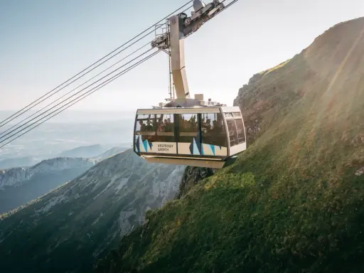 Kolejka linowa PKL Kasprowy Wierch wjeżdża na zbocze górskie, oferując pasażerom widok na Tatry.