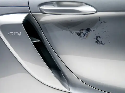 Na srebrnym lakierze Porsche GT4 schodzi lakier bezbarwny, tworząc nieestetyczne plamy. Jak naprawić ten problem?