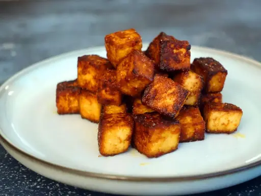 Goldbraun gebratene Tofuwürfel auf einem Teller, perfekt zum tofu zubereiten.