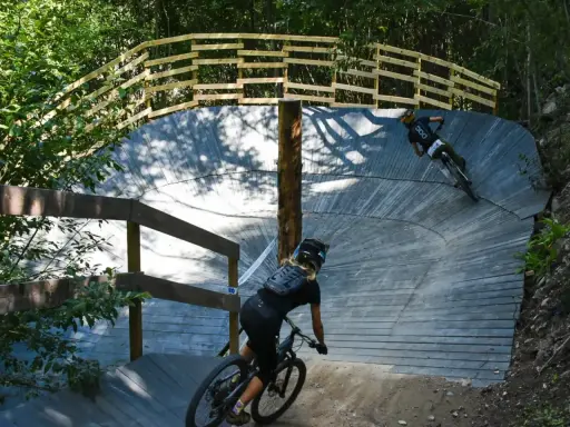 Två cyklister på en träbana i skogen, en spännande mtb-upplevelse nära Stockholm.