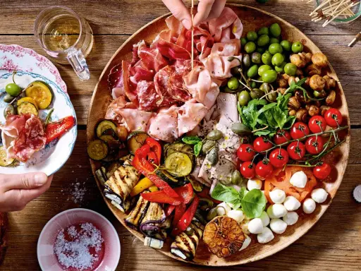 Große Platte mit Antipasti: Wurst, Schinken, Oliven, gegrilltes Gemüse, Tomaten, Mozzarella. Perfekt für Antipasti Rezepte.