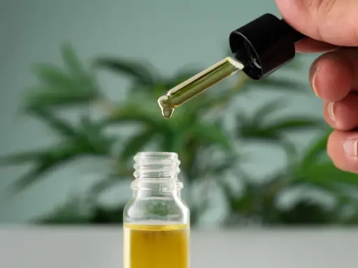 Une goutte d'huile essentielle tombe d'un compte-gouttes dans un flacon. Un remède naturel pour la toux grasse.