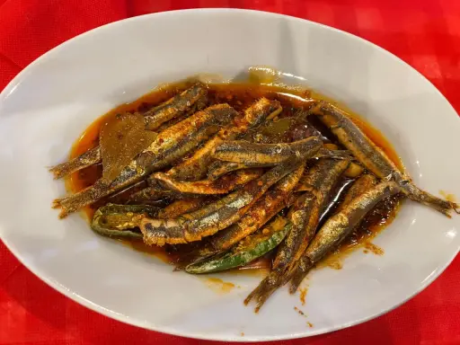 Piatto di alici marinate, un classico dei piatti tipici calabresi pesce, condite con olio, peperoncino e aromi.