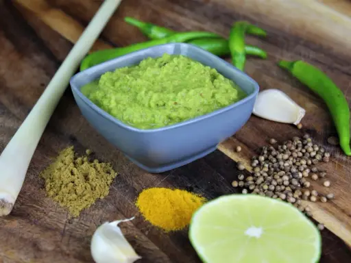 Frische Zutaten für **Currypaste selber machen**: grüne Chilis, Zitronengras, Knoblauch, Koriandersamen, Kurkuma, Kreuzkümmel und Limette.