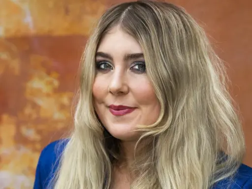 En kvinna med blont hår och smink, kanske redo att framföra sina miss li-låtar.