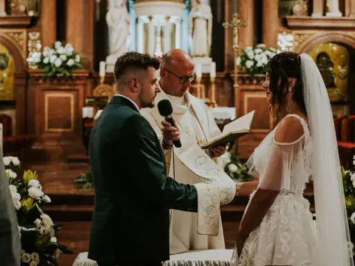 Para Młoda w kościele, kapłan czyta z księgi. Ślub kościelny to sakrament, który daje łaskę i błogosławieństwo.