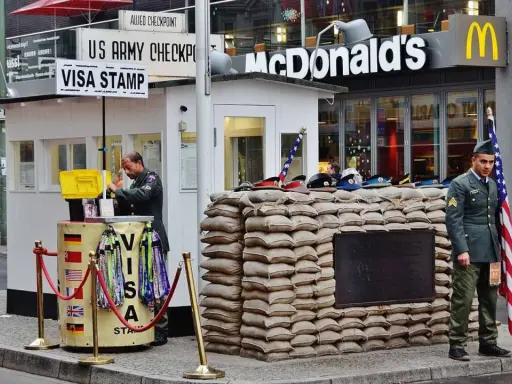 Checkpoint Charlie, ett måste att se i Berlin, med soldater och en McDonald's i bakgrunden.