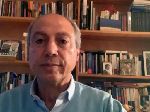 Carmine Abate, con libreria alle spalle, parla in videochiamata.