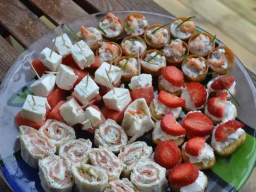 Enkla snittar till många: laxrullar, fetaost med vattenmelon, jordgubbar med grädde och räknyheter. Perfekt för festen!