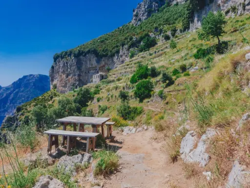 Un tavolo da picnic su un sentiero panoramico del Cammino degli Dei, Costiera Amalfitana. Vista mozzafiato sul mare e sulle montagne.