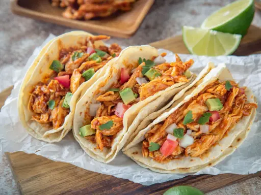 Drei saftige Hähnchen-Tacos mit Avocado, Tomaten und Koriander. Ein einfaches Tacos Rezept für den perfekten Genuss.