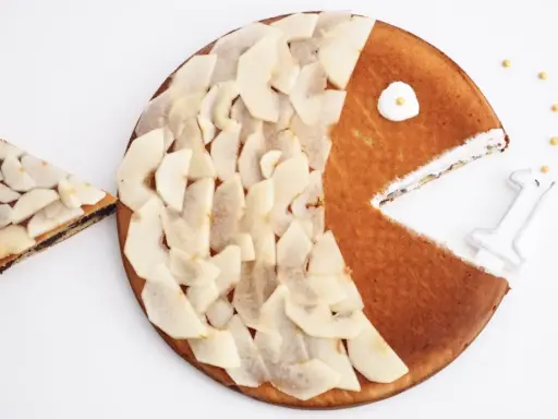Gâteau en forme de poisson pour enfant, décoré de fines tranches de poire. Une part a été retirée, comme si le poisson mangeait.