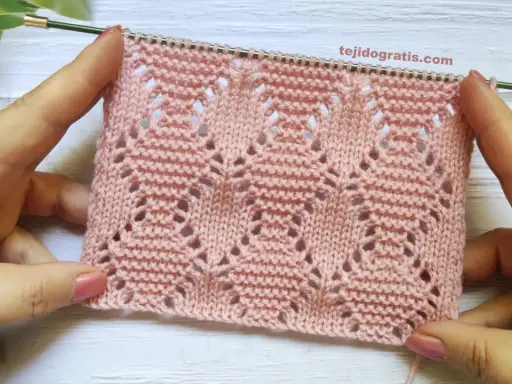 Muestra de tejido rosa con rombos a dos agujas patrones calados, ideal para prendas delicadas.