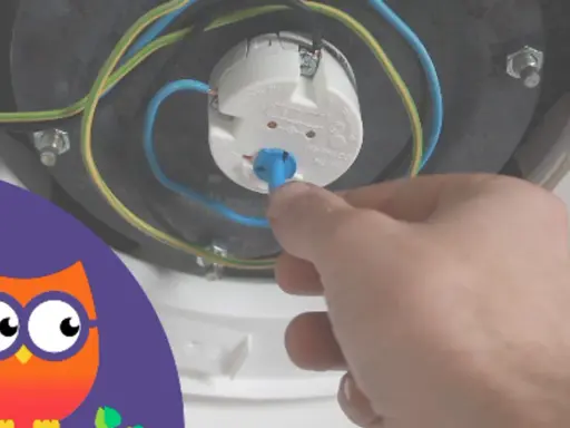 Main tenant ajuste le thermostat du chauffe-eau.