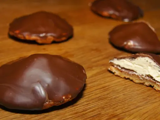 Chokladbiskvier recept: Läckra chokladöverdragna biskvier med krämig fyllning på en träyta.