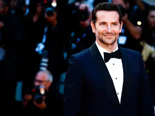 Bradley Cooper smiles, sporting a classic tuxedo. This image confirms that black tie does indeed mean tuxedo.