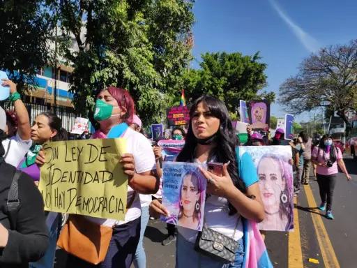 Protesters in El Salvador hold signs demanding identity rights and justice. One sign reads "Without identity law, there is no democracy.