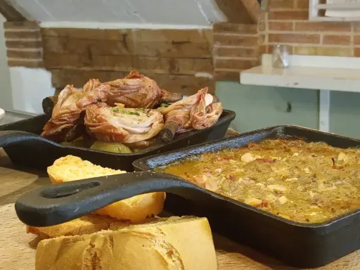 Deliciosa comida típica de Cuenca: pollo asado y un guiso con pan.