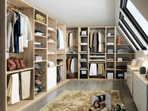 Un dressing bien organisé pour savoir comment ranger son dressing : vêtements suspendus, étagères remplies, tiroirs et accessoires à portée de main.
