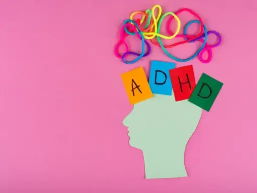 Kolorowe sznurki nad głową symbolizują chaos myśli. Kartki z literami A, D, H, D układają się w napis ADHD. To wizualizacja tego, czym jest autyzm.