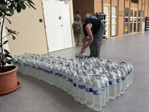 Une femme arrange des bouteilles d'eau potable, prêtes pour une distribution à Angers.