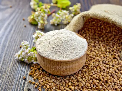 Blé noir et sarrasin : une différence subtile entre la graine et la farine. Le sarrasin, aussi appelé blé noir, se présente ici en grains dans un sac et en farine dans un bol en bois.