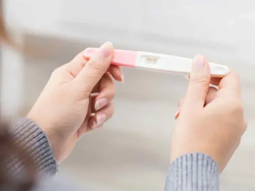 Kvinna håller graviditetstest. Ett streck syns, vilket indikerar negativt resultat, trots att hon känner sig gravid i vecka 7.
