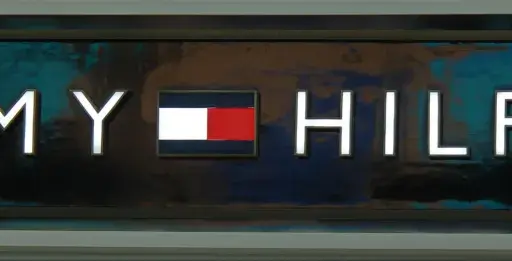Litery TOMMY HILFIGER na tle z efektem marmuru. Poznaj, jak rozpoznać podróbkę Tommy Hilfiger, zwracając uwagę na detale logo.