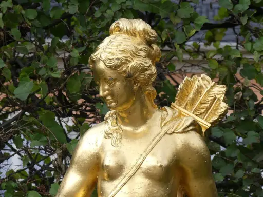 Statue dorée d'Artémis, déesse de la chasse, portant un carquois rempli de flèches sur son épaule.